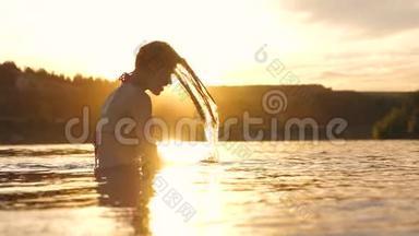 在热带小岛附近一个清爽的夏日傍晚，嬉戏的女孩在清爽的河水中溅出长发